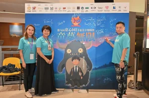 晴天基金與主席黃君俠 P Wong 在童心同行慈善音樂晚會簽名板前與義工成員合照。