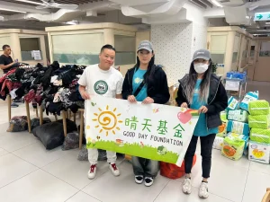 黃君俠（P. Wong）與晴天基金及私董善愛義工在大埔宏福苑展示捐贈橫幅及物資的合照。