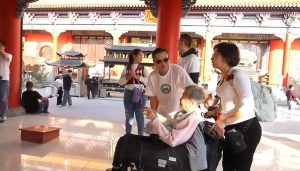 黃君俠主席於東莞廟宇內帶領私董善愛圓夢行動義工，陪伴長者坐輪椅完成尋根旅程的重要時刻