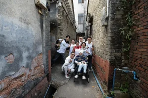 黃君俠主席帶領私董善愛圓夢行動義工，陪伴長者坐輪椅走進東莞舊巷，重返成長記憶之路